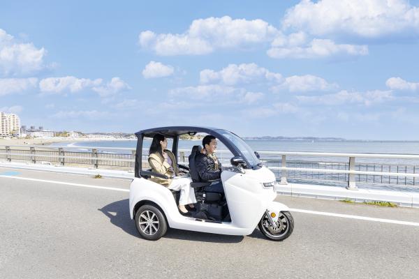 笑顔でトゥクトゥクに乗る人の写真